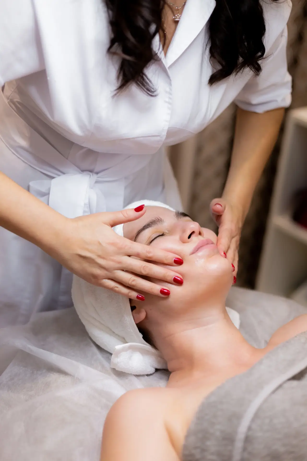 young beautiful girl lies beautician s table receives procedures light facial massage scaled